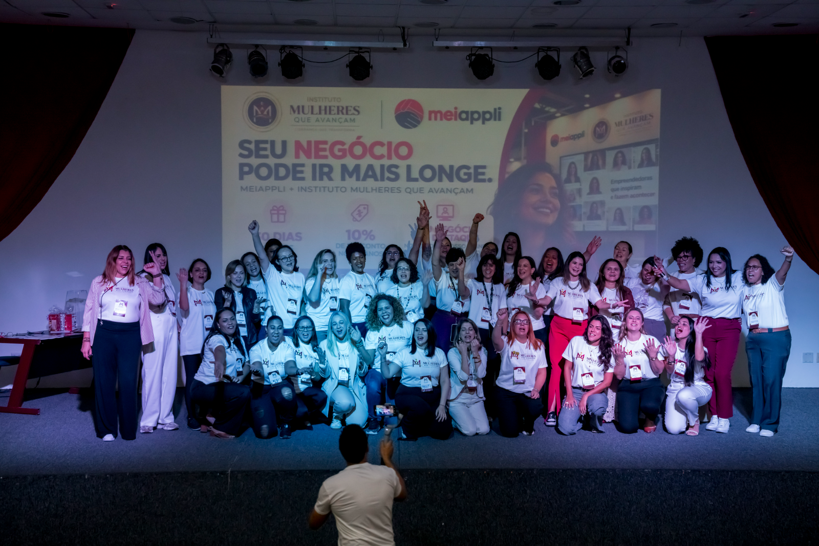 Participantes do Fórum das Profissões no palco, com camisetas do Instituto Mulheres que Avançam